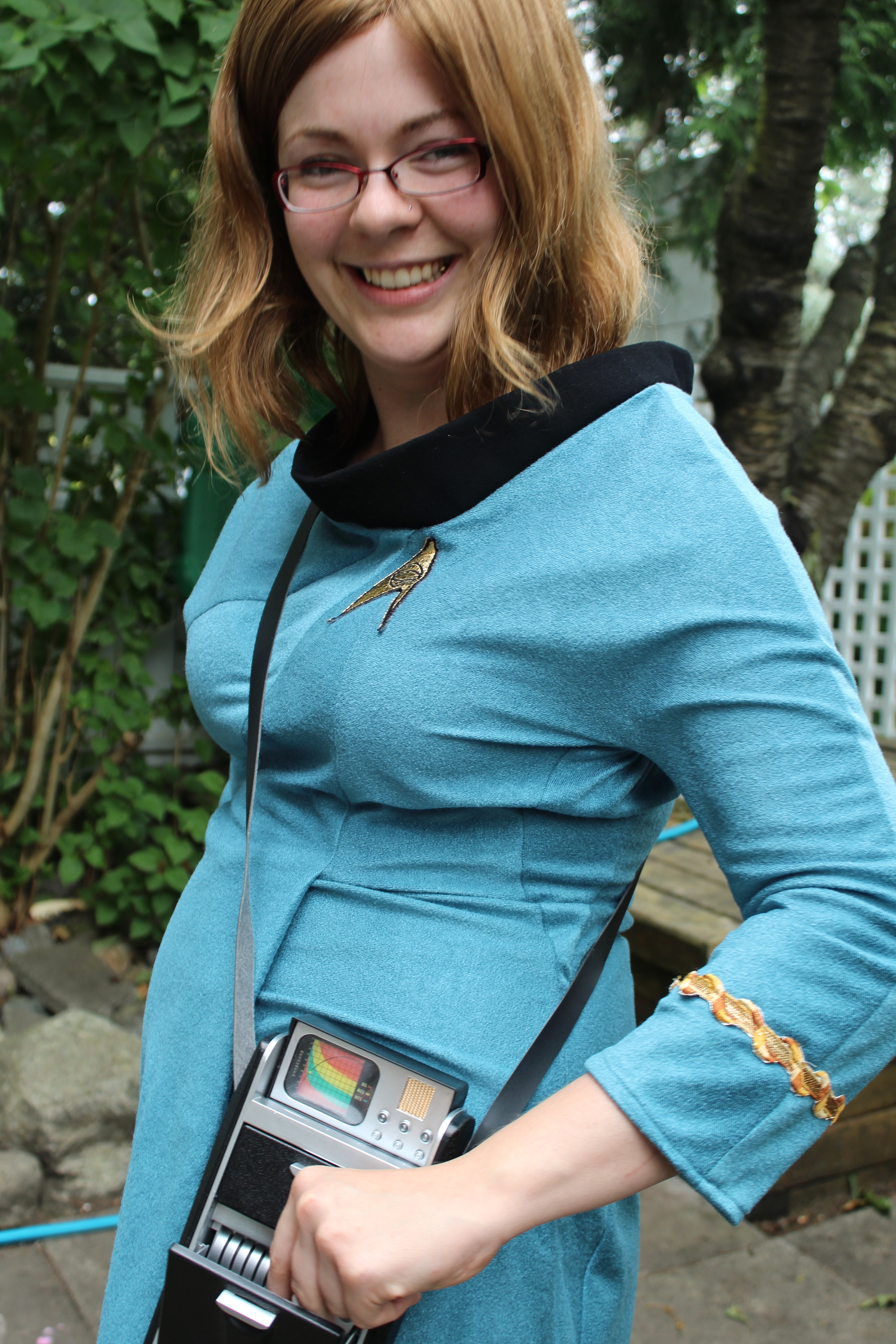 Jarrah in a TOS blue science uniform with tricorder